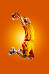 Wall Mural - bright professional basketball player on an orange background