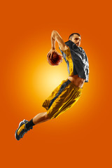 Wall Mural - bright professional basketball player on an orange background