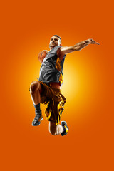 Wall Mural - bright professional basketball player on an orange background