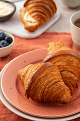 Wall Mural - Fresh croissants with blueberries and honey, gray background.