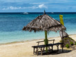 Sonnenschirm aus Palmblättern mit Bank am weißen Sandstrand Anda Insel Bohol auf den Philippinen