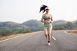 Photo fone view Asia young smiling woman runner running on asphalt road, female in sport cloth and wear a hat jogging
