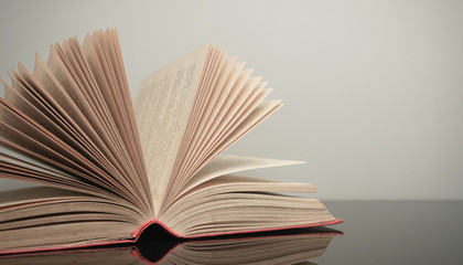 Poster - Close up beautiful open book on a gray and glass table background.