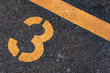 © RPA_studio - Asphalt parking lot with yellow lot line and yellow lot number 3