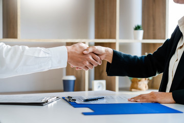 Wall Mural - businessman and businesswoman handshaking over the office desk after Greeting new colleague, business meetings concept