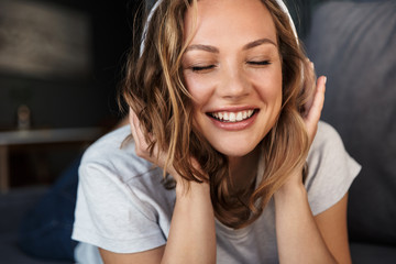 Sticker - Image of smiling blonde woman using wireless headphones