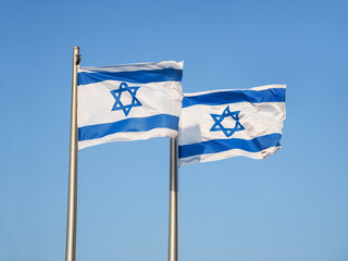 Two national flags of Israel outdoors against the blue sky