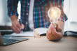 businessman hand holding lightbulb with office tools  on desk. idea, innovation inspiration concept.