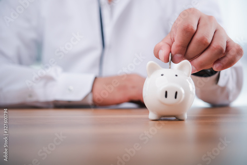 Fotografía businessman hand putting coins with piggy bank