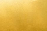 Fototapeta  - Gold wall texture background. Yellow shiny gold foil paint on wall surface with light reflection