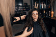 © Zoran Zeremski - Female hairdresser makes hairstyle on young woman with brunette hair in salon.