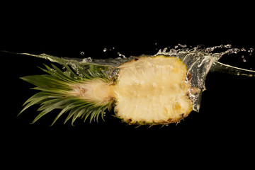 Aufkleber - Half of juicy pineapple falling into transparent water on black background