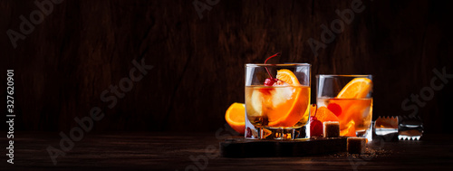 Fotografía Alcoholic old fashioned cocktail with orange slice, cherry and orange peel garni