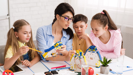 Children learning about computers and robots with their teacher