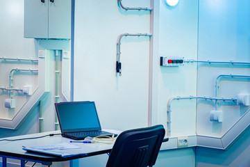 Poster - laptop in the technical room. premises with lots of switches. utility room. electricity control cent