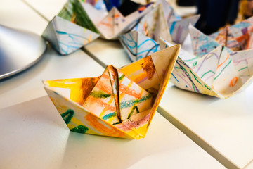 Homemade paper boats decorated with colors for children a day of crafts.