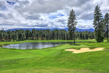 Golf Course With Pine Trees And Pond In Cascade Mountains Of Northwest With Little House.