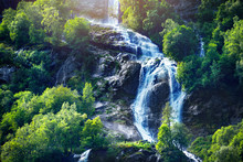 Panoramic Beautiful Deep Forest Waterfall In Norway Near Blue Ocean. Waterfalls Mountain View Close Up.