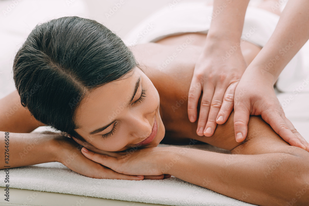 Beautiful woman enjoying massage at the spa. - obrazy, fototapety, plakaty 