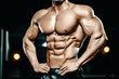 © antondotsenko - Bodybuilder strong man pumping up abs muscles
