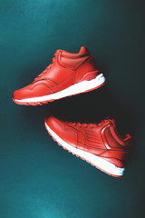 Red sneakers on blue background. Concept of sport and healthy lifestyle. Place for text, flat lay, top view, vertical.