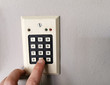 A finger pressing security code, keywords or passwords on a numeric keypad
