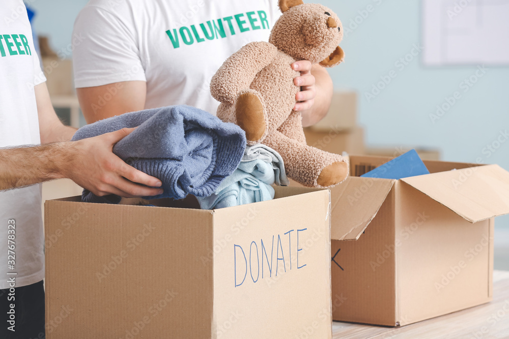 Volunteers with donations for poor people indoors