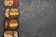 Containers with healthy food on dark background