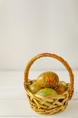 trendy modern easter multicolored, originally painted, marble eggs in a basket on a light background with place for text