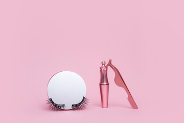 Wall Mural - Magnetic fake eyelash in mirror kit, eye liner, tweezers isolated on pink background. Eyelash extension cosmetology tool concept, beauty treatment, improving physical appearance. Soft selective focus