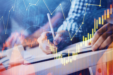 Multi exposure of two men planing investment with stock market forex chart.