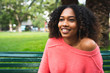 © Mego-studio - Portrait of young afro-american woman sitting outdoors at park.