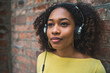 © Mego-studio - Portrait of young afro-american woman listening music with headphones.