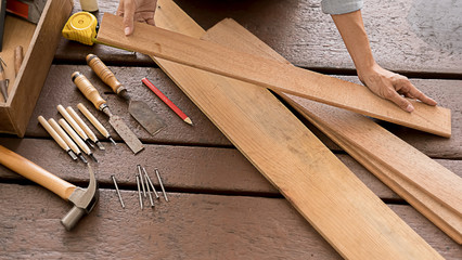 Wall Mural - Carpenter working with equipment on wooden table in carpentry shop. woman works in a carpentry shop.