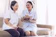 © anon - Health visitor and a senior woman during home visit.beautiful  Asian nurse taking care of senior patient