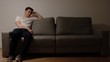 © Cliplab - Depressed young adult man on a grey sofa in the night