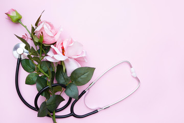 Wall Mural - Roses with stethoscope on pink background. Top view with copy space. National Doctor's day. Happy nurse day.