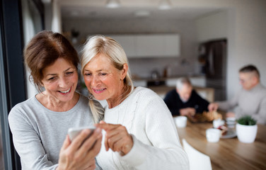 Sticker - Group of senior friends at home, using smartphones.