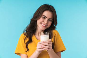 Wall Mural - Positive optimistic young beautiful woman holding milk.