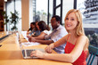 © Monkey Business - Portrait Of Businesswoman Working At Desk In Shared Open Plan Office Workspace