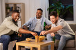 © Syda Productions - friendship, leisure and people concept - male friends drinking beer and eating crisps at home at night