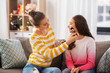 © Syda Productions - people and friendship concept - happy teenage girls sitting on sofa and doing make up at home