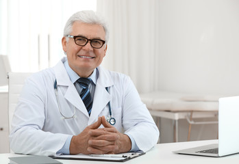 Canvas Print - Portrait of senior doctor in white coat at workplace