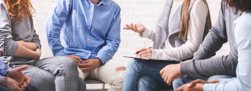 Cuadros en Lienzo Mentor discussing problem with therapy group members at meeting in rehab