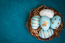 Easter Background With Easter Eggs In Bird Nest On Blue Background