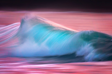 Wall Mural - Photo of turquoise wave at sunset with in camera panning technique