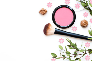 Makeup brush, rouge.Pink flowers and green branches. 