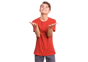 Portrait of teen boy raised hands and trying to catch something. Cute caucasian young teenager smiling and looking up, isolated on white background. Joyful child having fun.