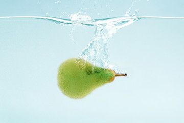 Aufkleber - Juicy pear flying into water with splash on blue background