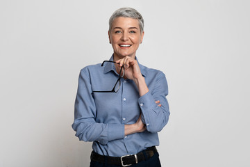 Portrait Of Beautiful Mature Businesswoman Holding Glasses And Smiling At Camera